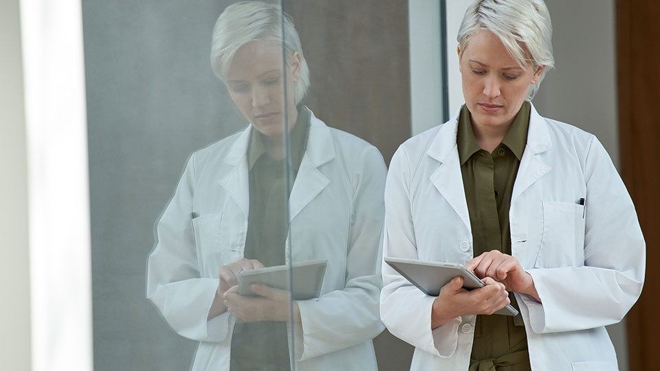 A medical professional holding a tablet