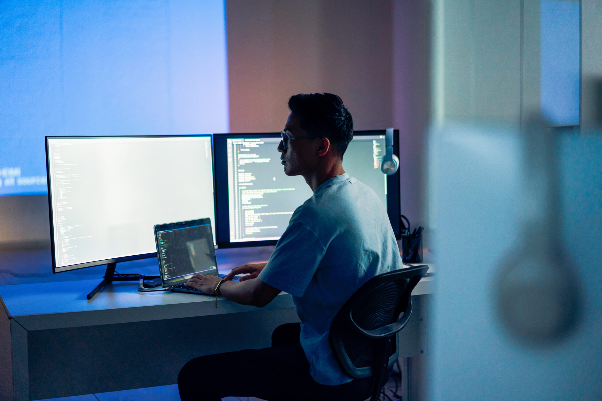 Web design, coding and Asian man with a computer for programming a website at night. Cyber security, developer and programmer reading information for a software database on a pc in a dark office
